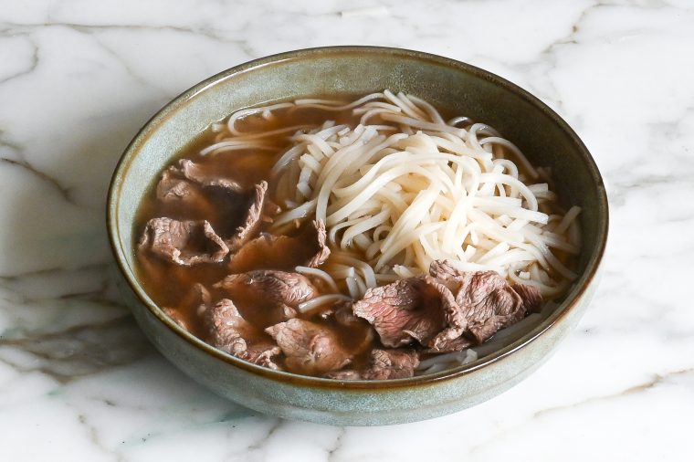 pho noodles, beef, and broth in bowl
