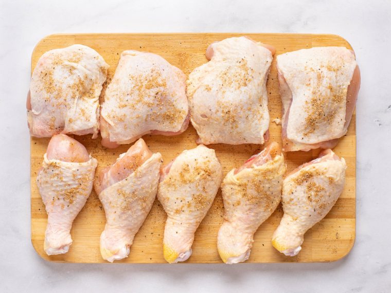 seasoning chicken on cutting board
