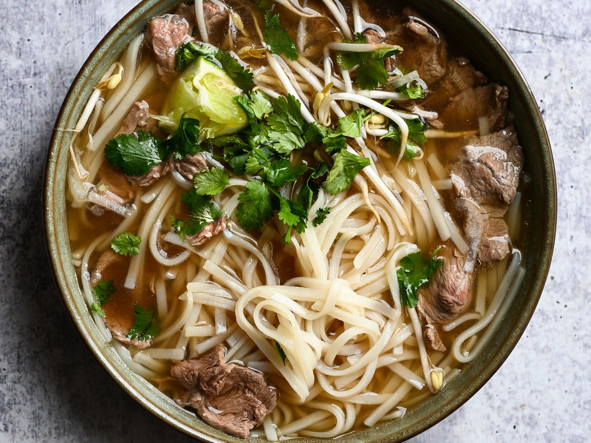 bowl of pho with lime and cilantro