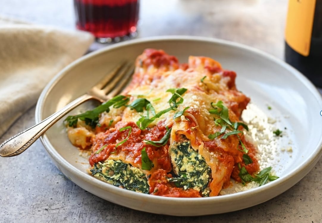 Manicotti with spinach and cheese filling on serving plate.