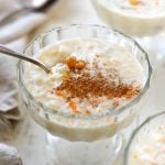 Spoon in a stemmed glass of rice pudding.