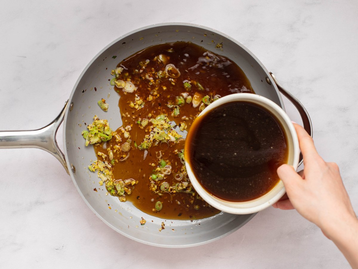 adding the sauce to the aromatics