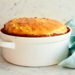 Cheese souffle in a white, handled dish.