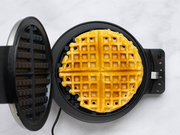 golden brown waffles in waffle iron.
