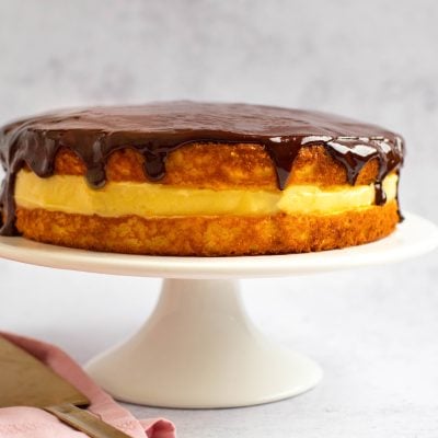Boston cream pie on a raised serving platter.