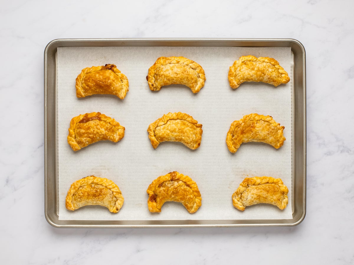 baked empanadas cooling on baking sheet