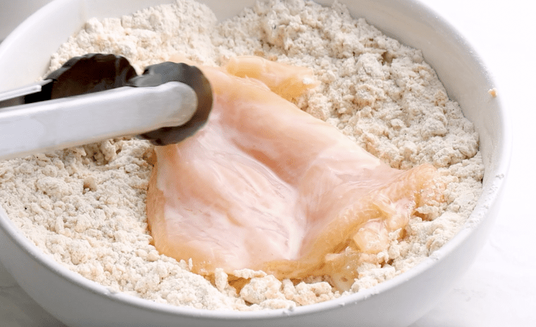 dredging the chicken in the flour mixture