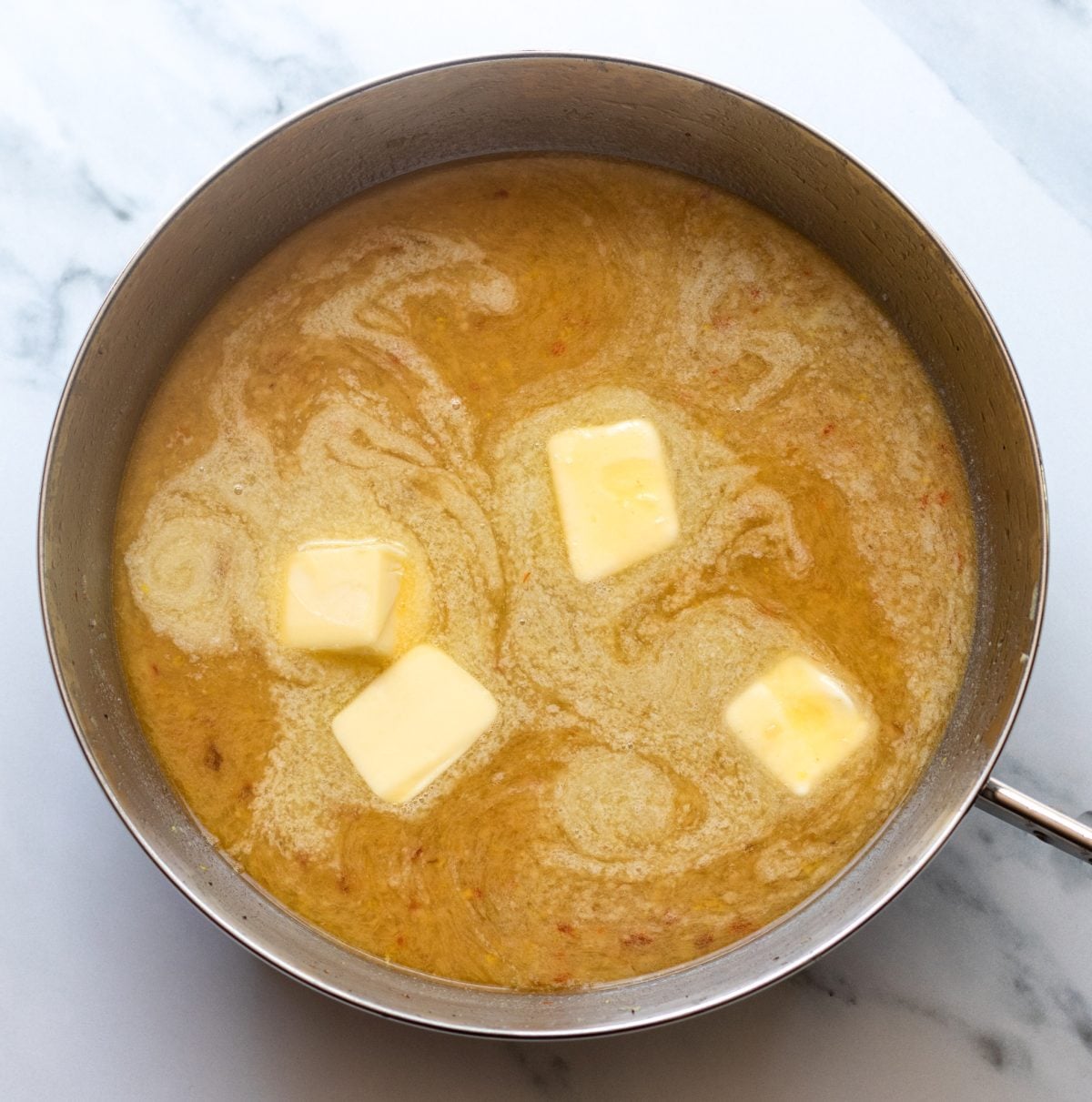 Butter, lemon juice and lemon zest, ½ cup of the reserved cooking water, and ½ teaspoon salt simmering in the skillet
