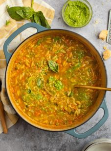 Ladle in a pot of vegetable soup with pesto.