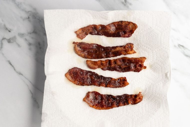 cooked bacon draining on paper towels