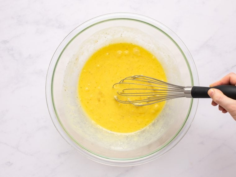 whisking eggs, heavy cream, salt, and pepper