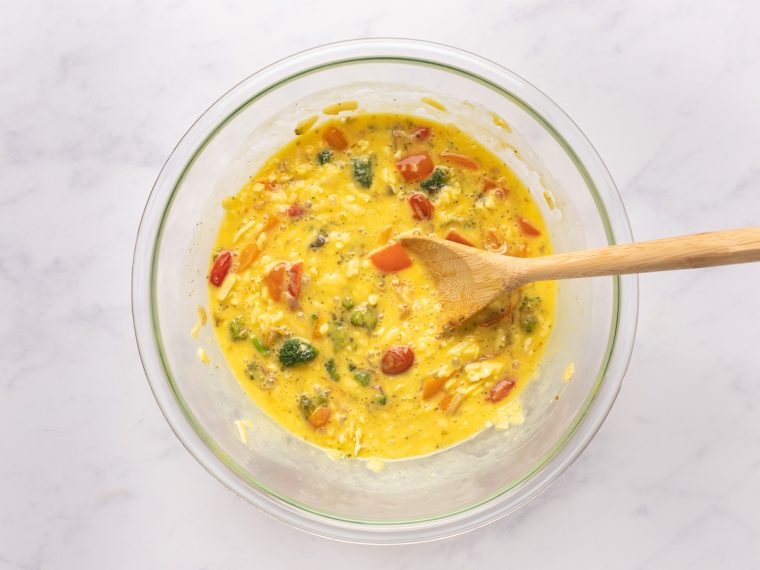stirring vegetables and cheese into egg mixture