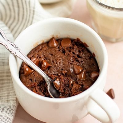 brownie in a mug with glass of milk