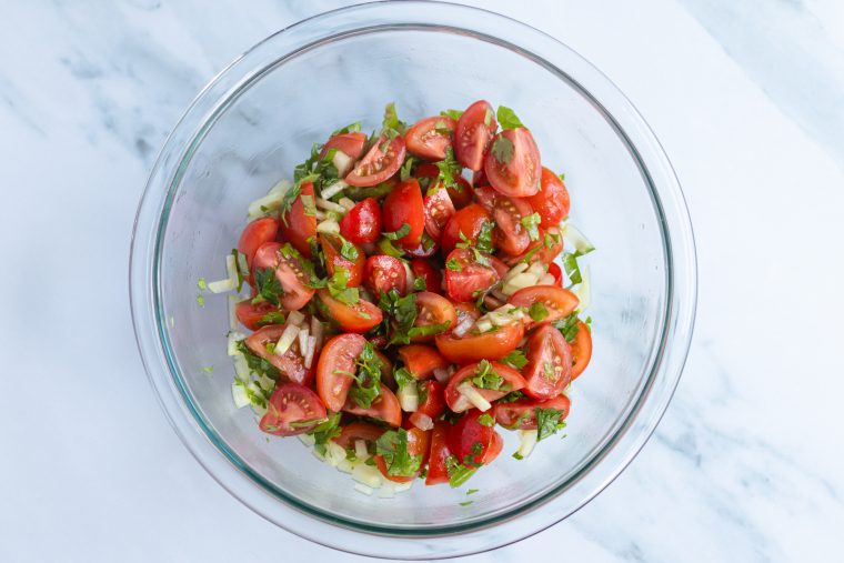 Tomato-cucumber salad in a glass bowl.