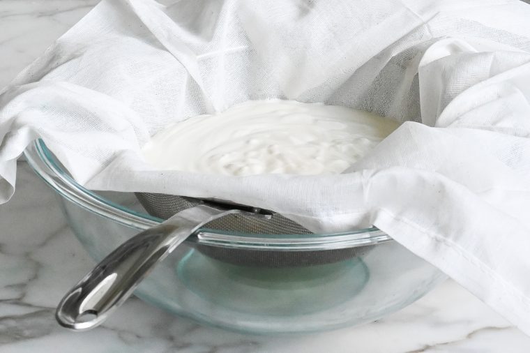 yogurt sitting in cheesecloth and colander