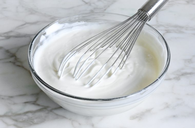 whisking yogurt and salt in mixing bowl