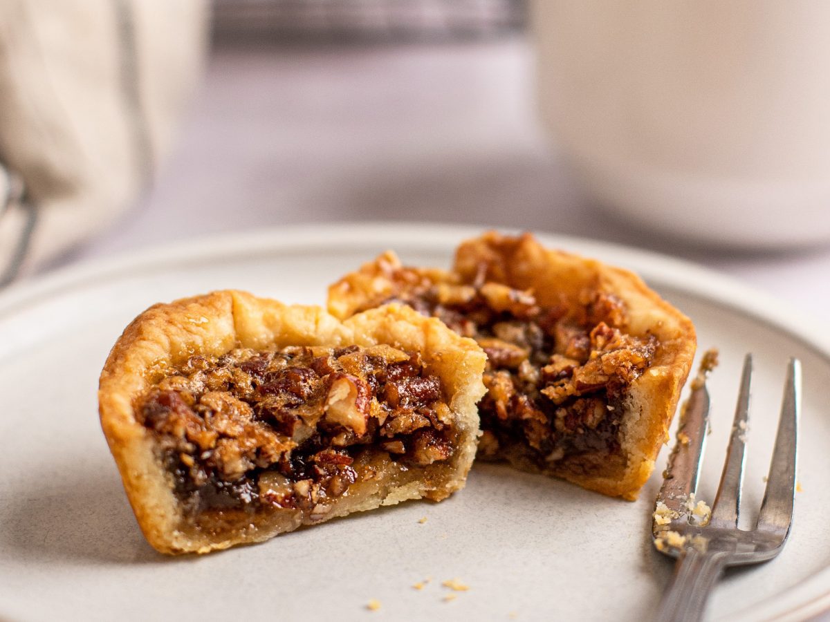 Canadian butter tart cut in half with fork on plate