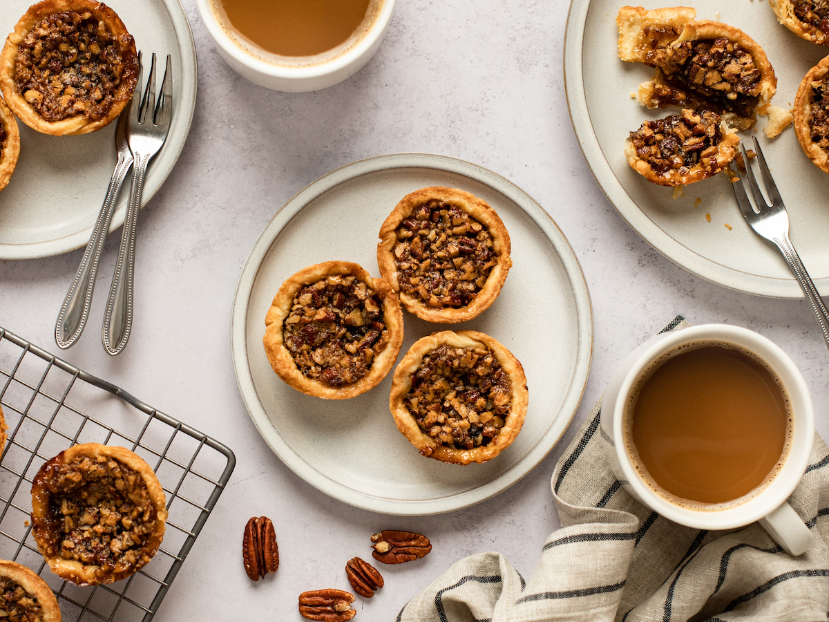 butter tarts on plates with coffee.