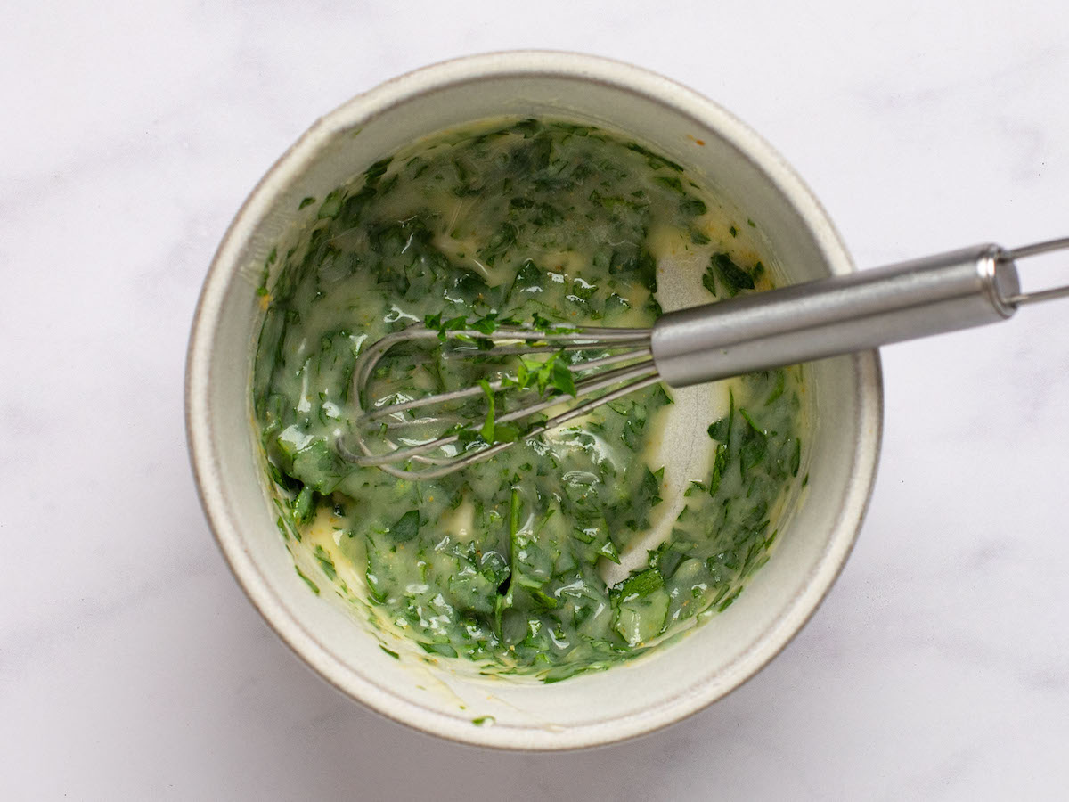 whisking melted butter, garlic powder, and parsley in a small bowl