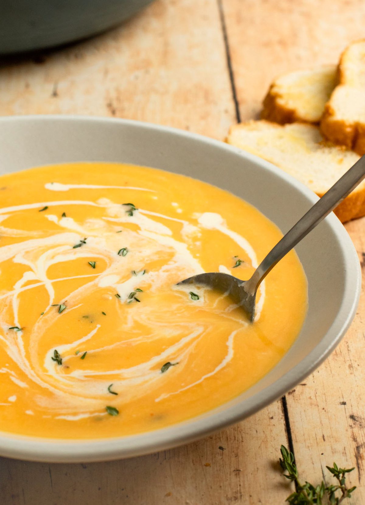 Spoon in a bowl of butternut squash soup.