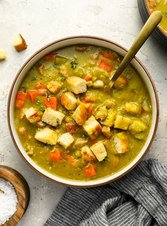 Bowl of split pea soup topped with croutons.
