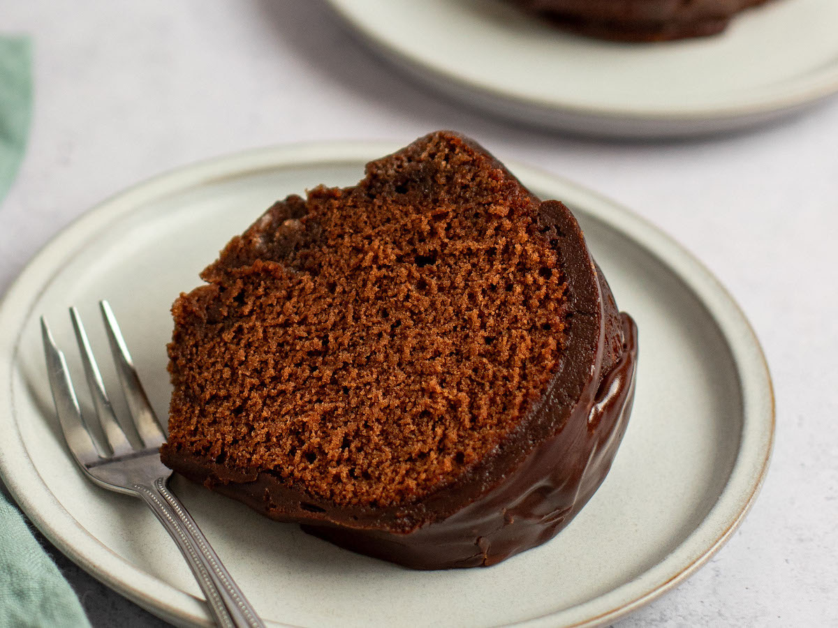 Slice of chocolate bundt cake on a small plate with a fork.