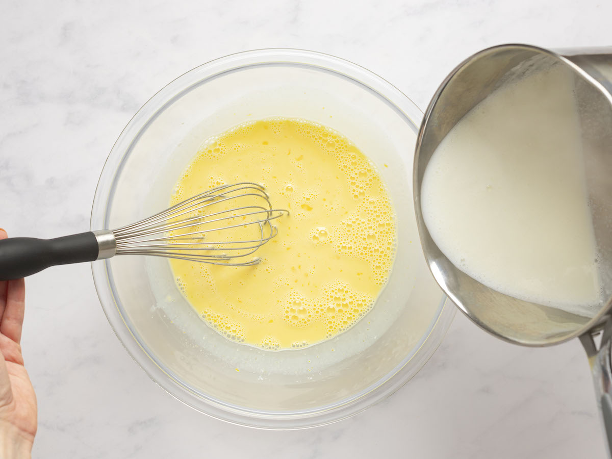 adding milk into yolk mixture and whisking constantly