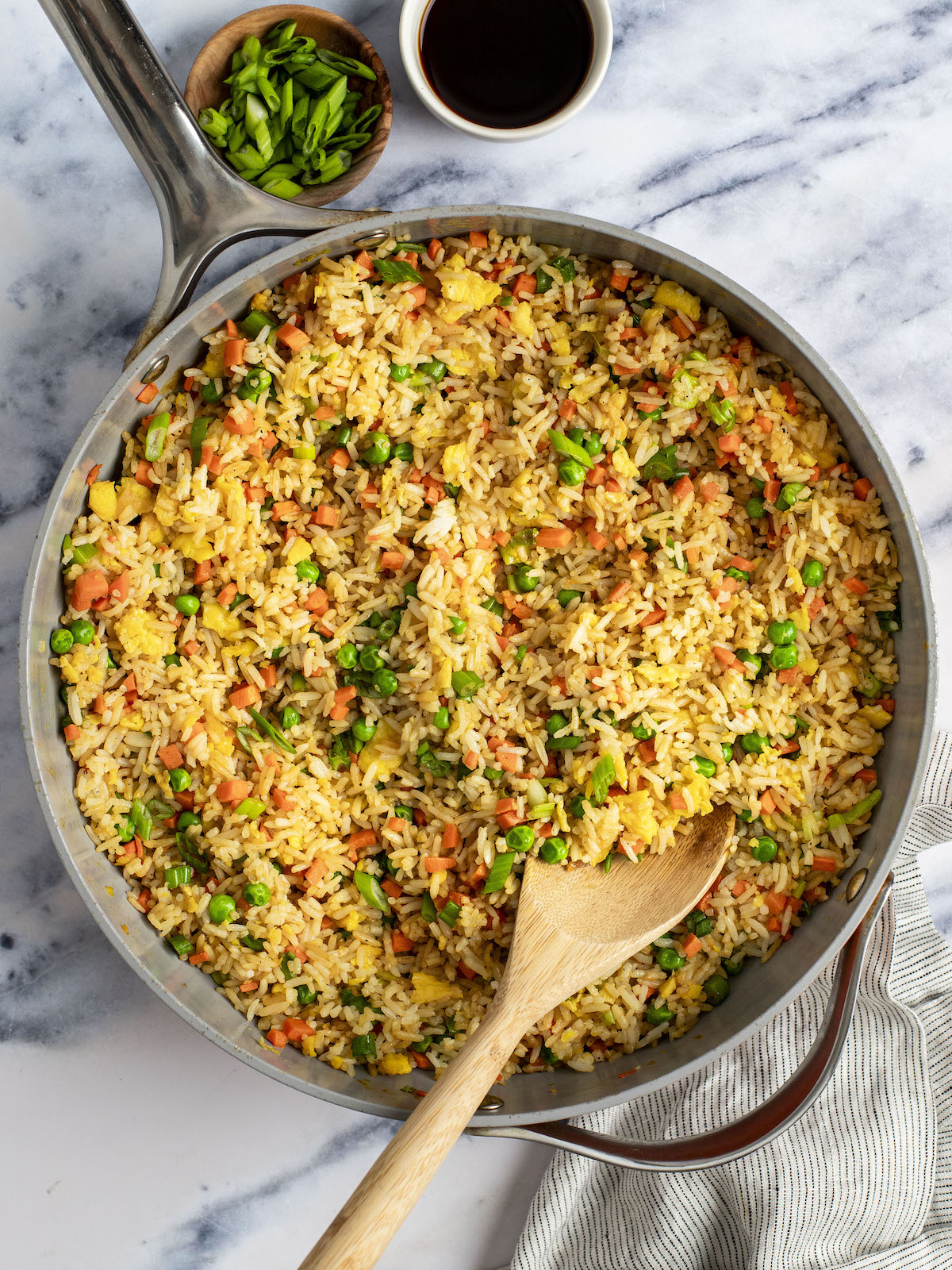 fried rice in skillet with small bowls of soy sauce and scallions