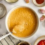 sun-dried tomato and red pepper aioli in a bowl with ingredients surrounding it