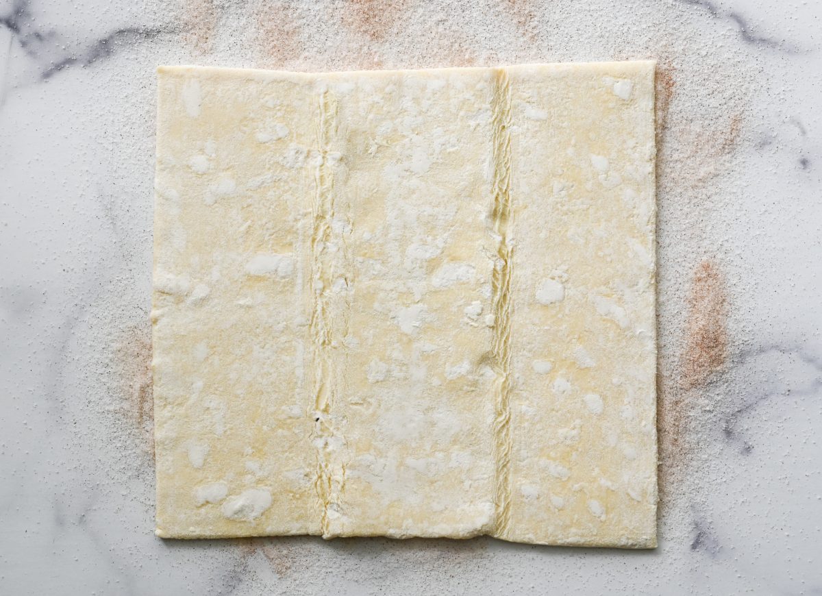 puff pastry unfolded on sugared surface