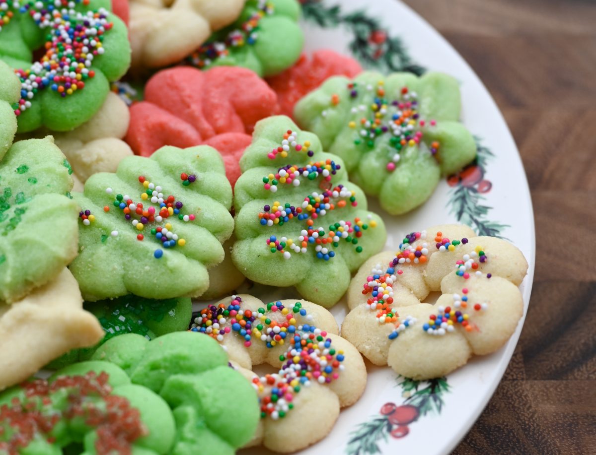 Colorful spritz cookies on a Christmas plate.