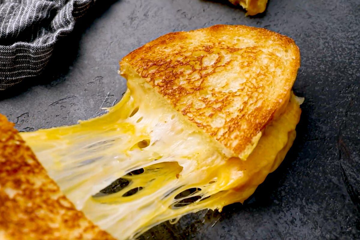 pulling apart a cheesy grilled cheese sandwich.