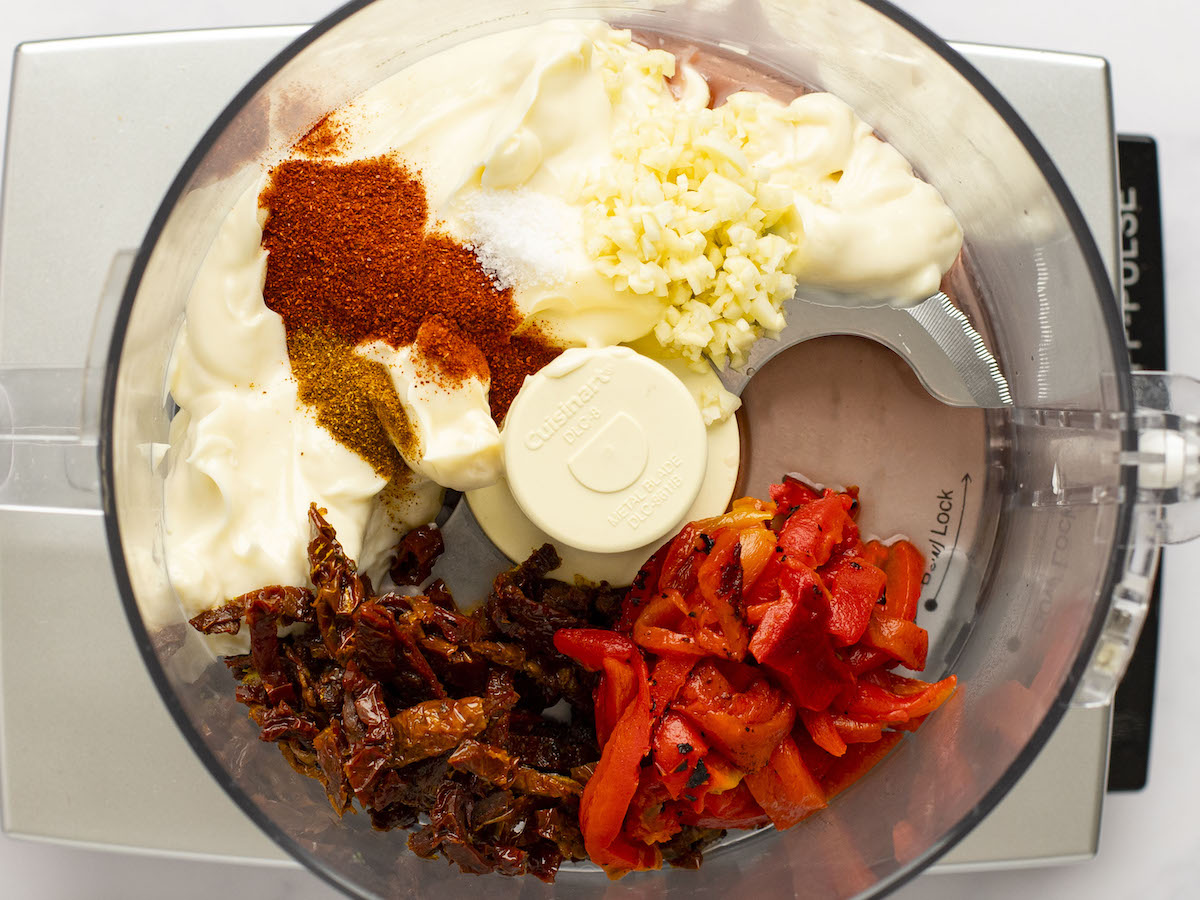 mayonnaise, roasted red peppers, sun-dried tomatoes, garlic, vinegar, smoked paprika, salt, cayenne pepper in food processing bowl