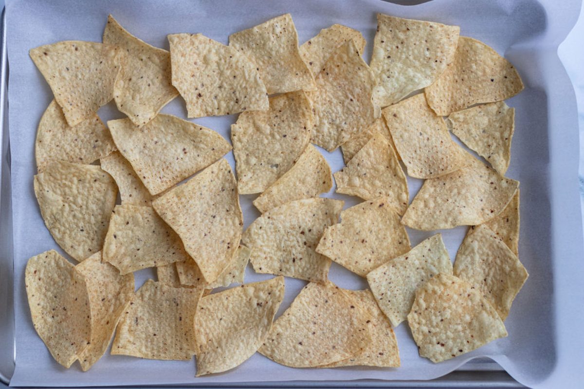 1/2 of tortilla chips on parchment lined baking sheet