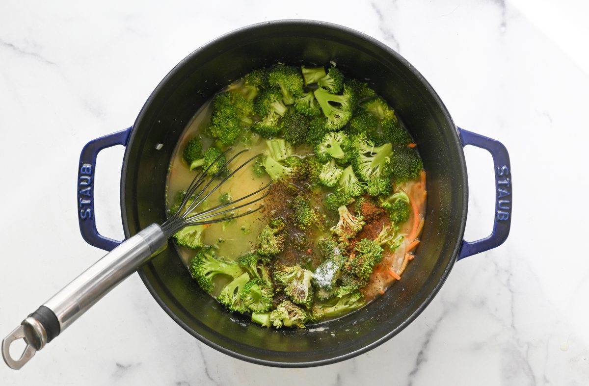 adding broccoli, seasoning, and broth to pot