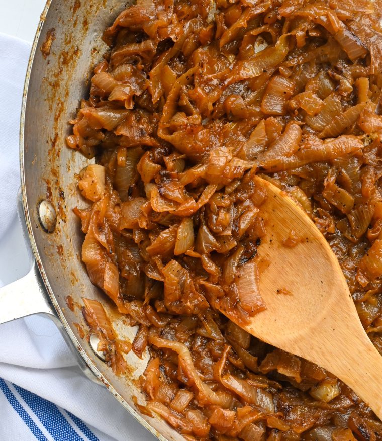 caramelized onions in skillet with wooden spoon