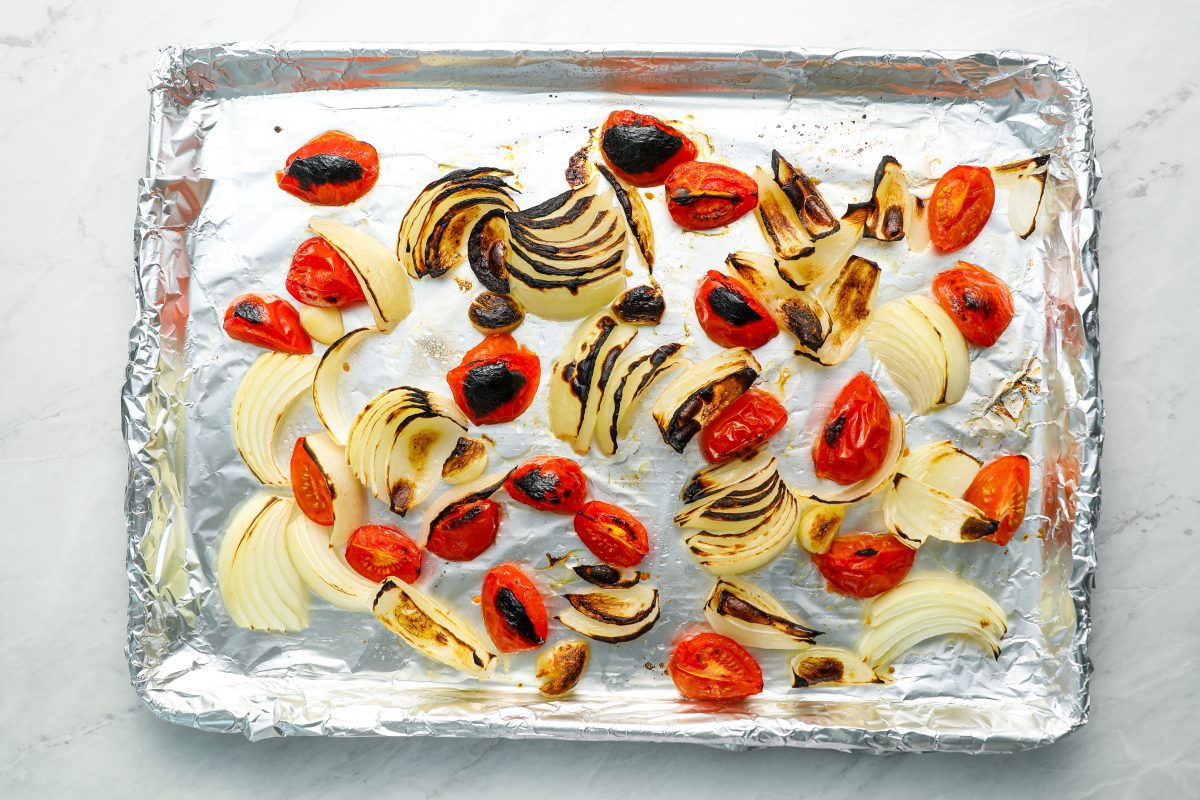 roasted tomatoes and vegetables on baking sheet.