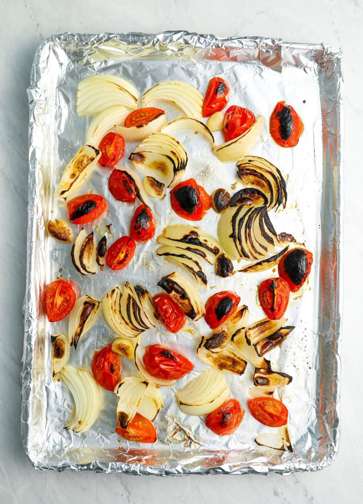 roasted tomatoes and vegetables on baking sheet.