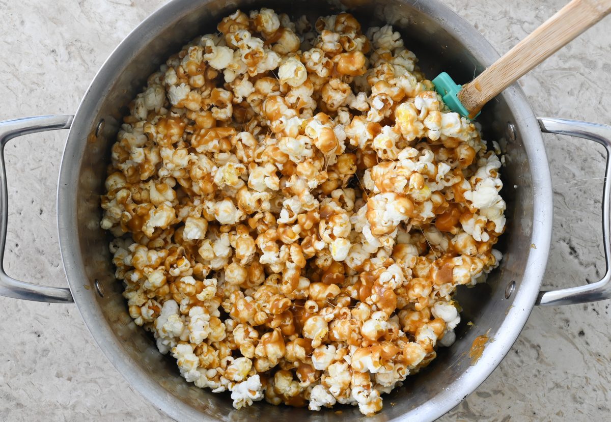 mixing caramel with popcorn