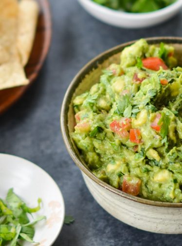 bowl of guacamole with chips.