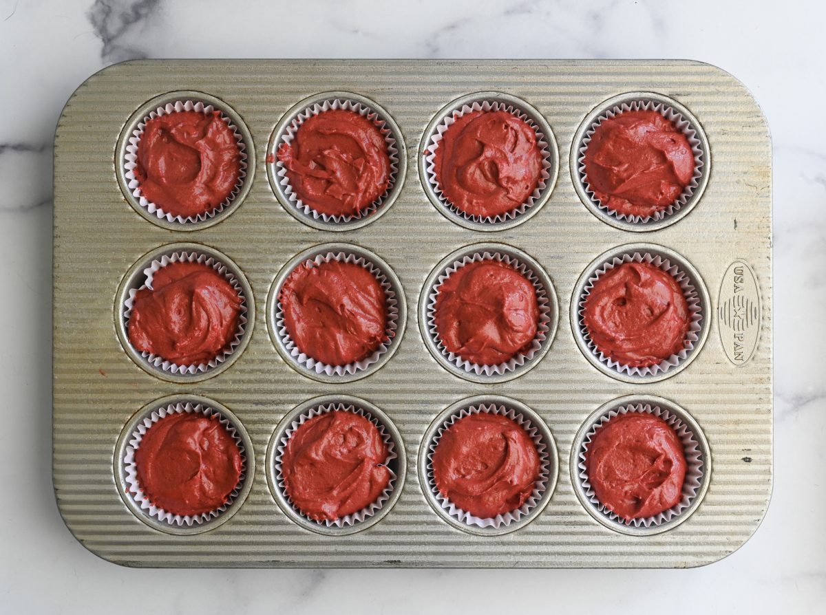 red velvet cupcake batter spooned into muffin tin and ready to bake.