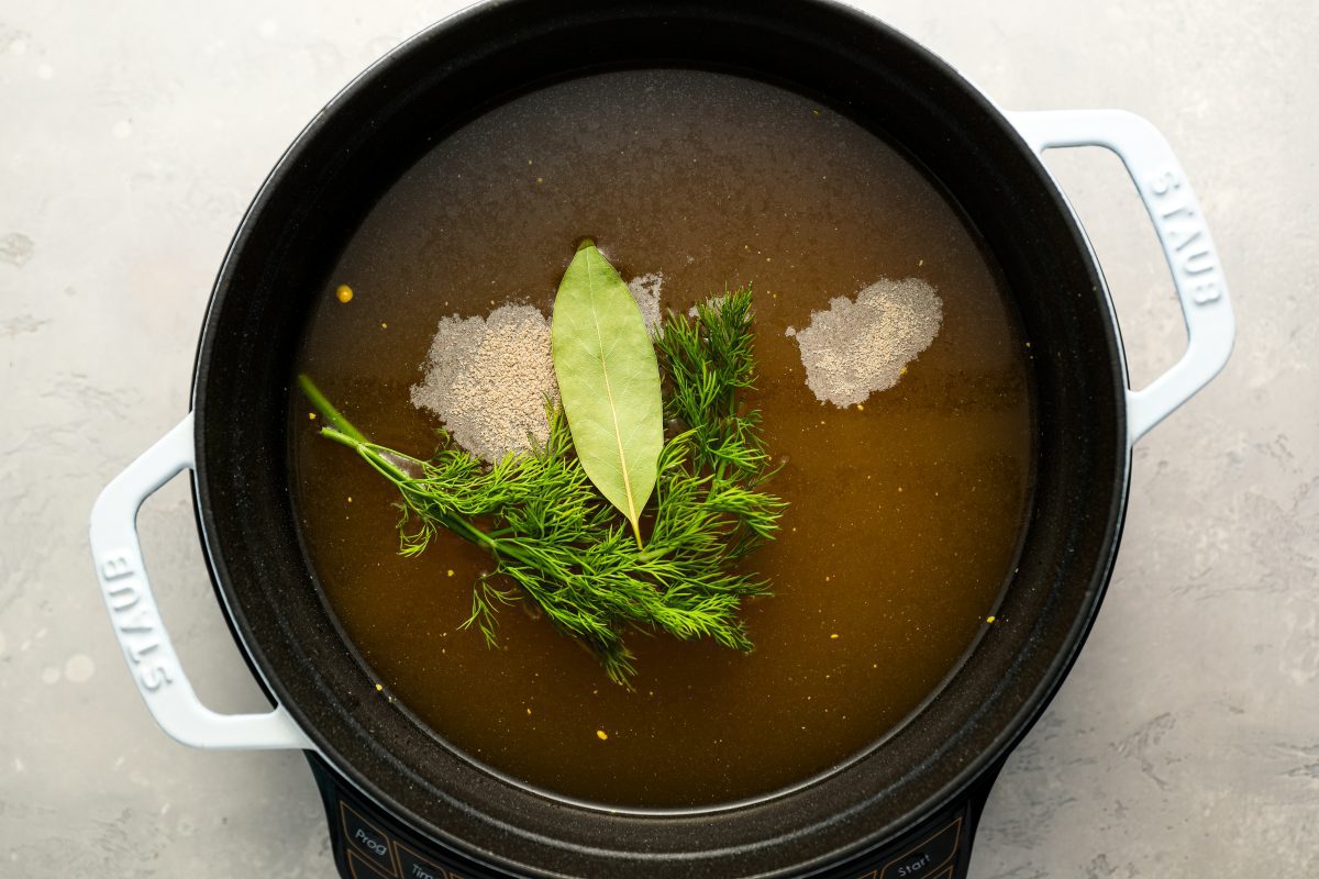 broth, seasoning, and aromatics in pot.