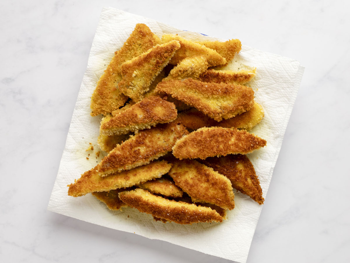 fried fish on paper-towel lined plate