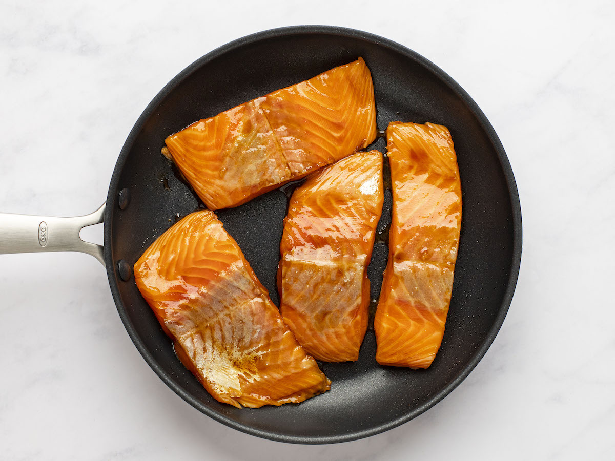 searing marinated salmon in skillet.