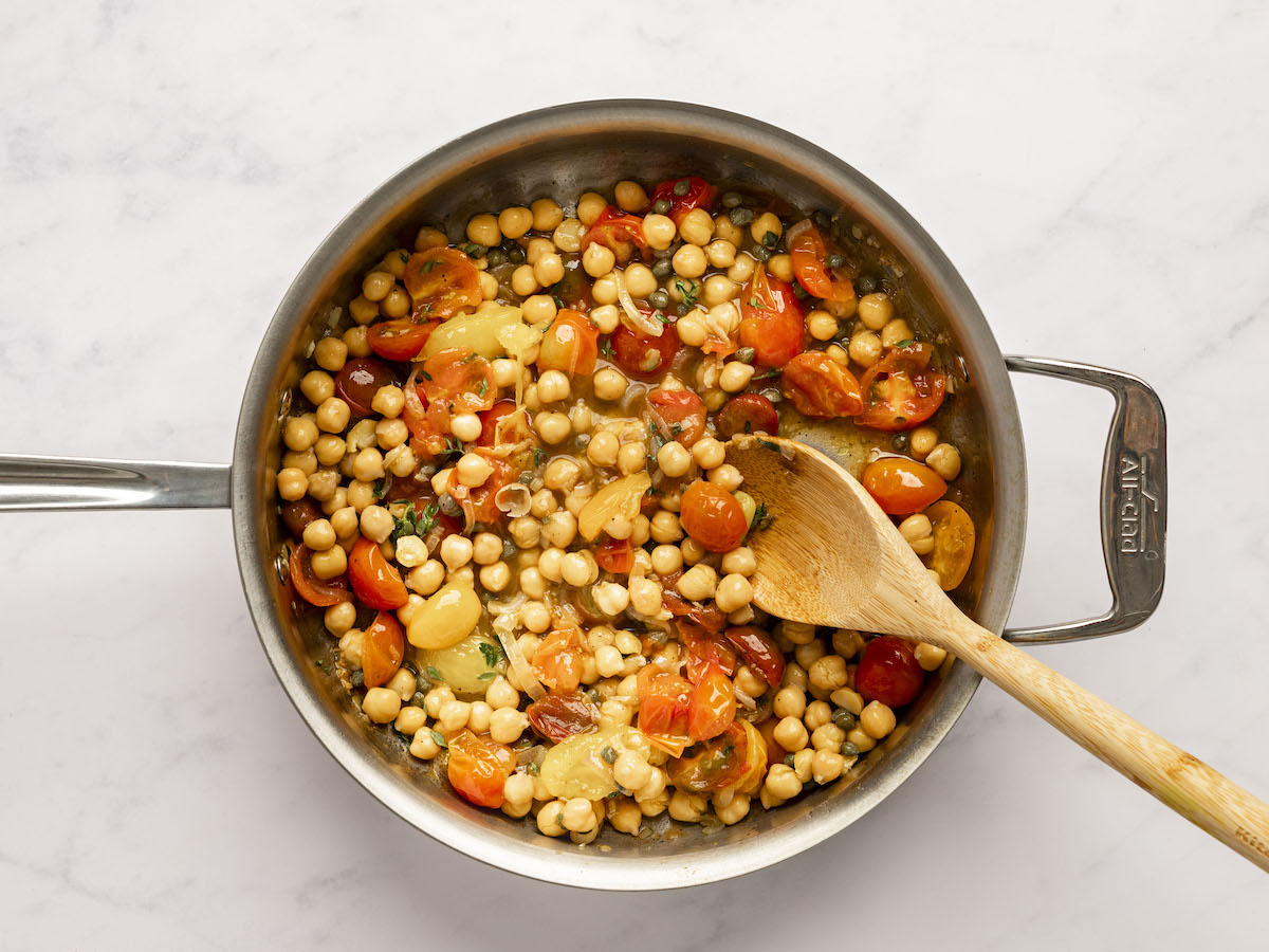 chickpeas, capers, vinegar, and thyme added to large pan with tomatoes, garlic, and shallots