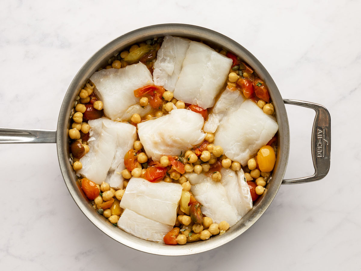 Cod put in large pan with tomato chickpea mixture
