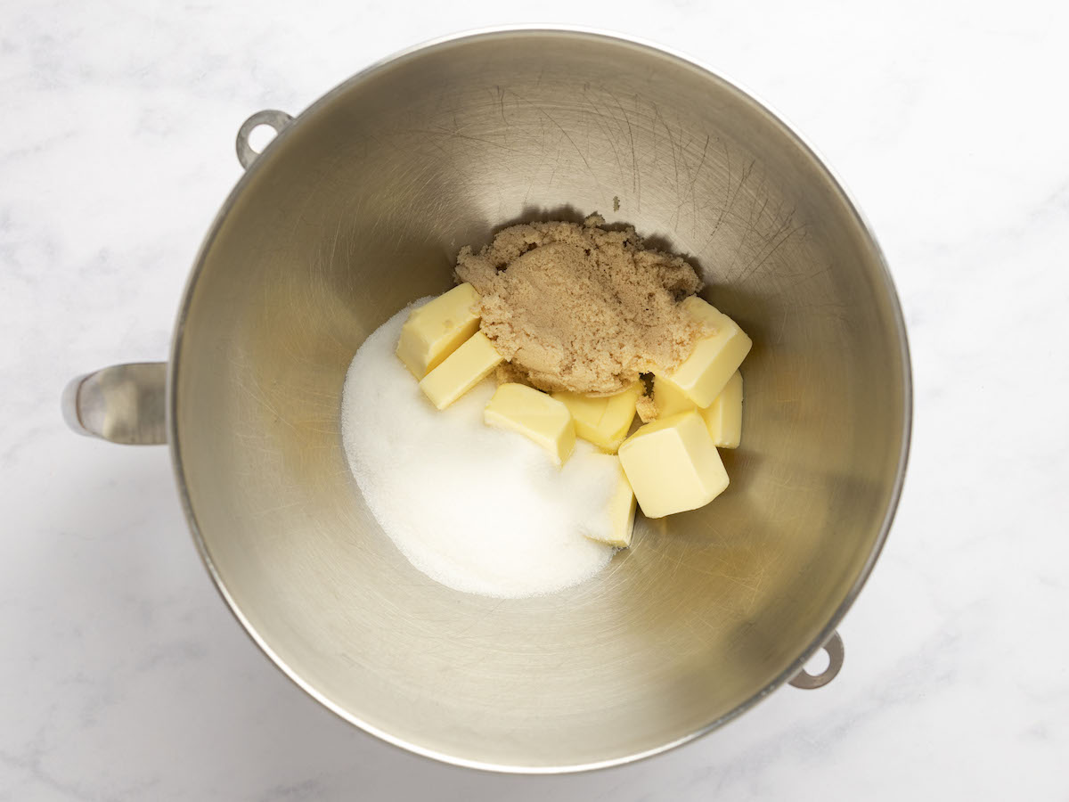 butter with the granulated sugar and brown sugar in bowl of electric mixer.