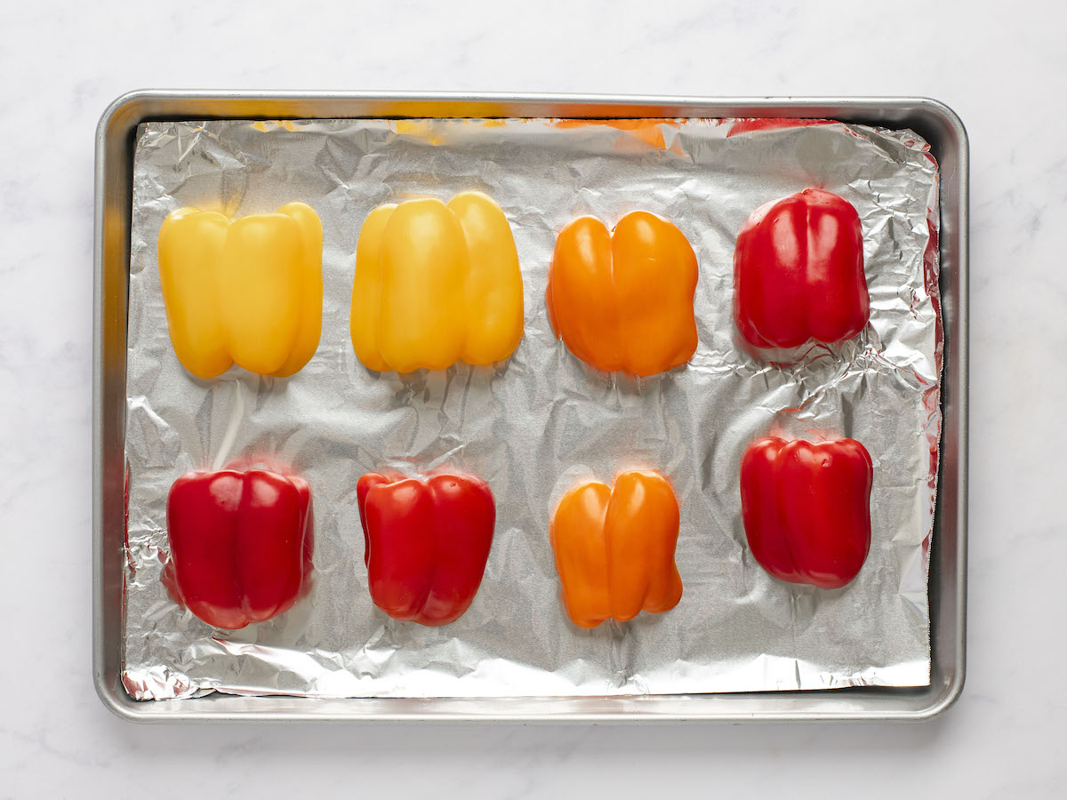 halved peppers on foil-lined baking sheet.