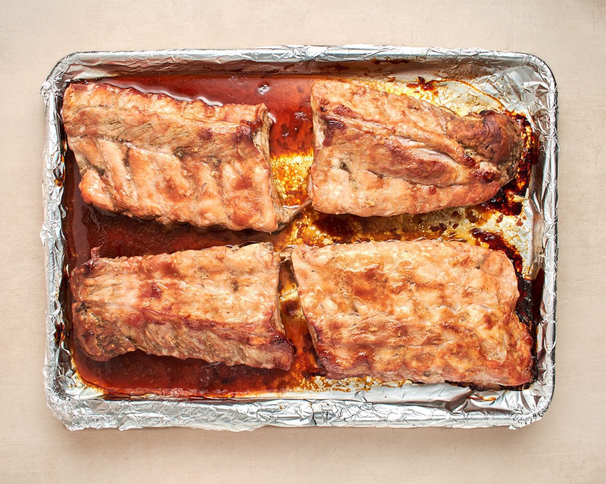 partially baked ribs on baking sheet.