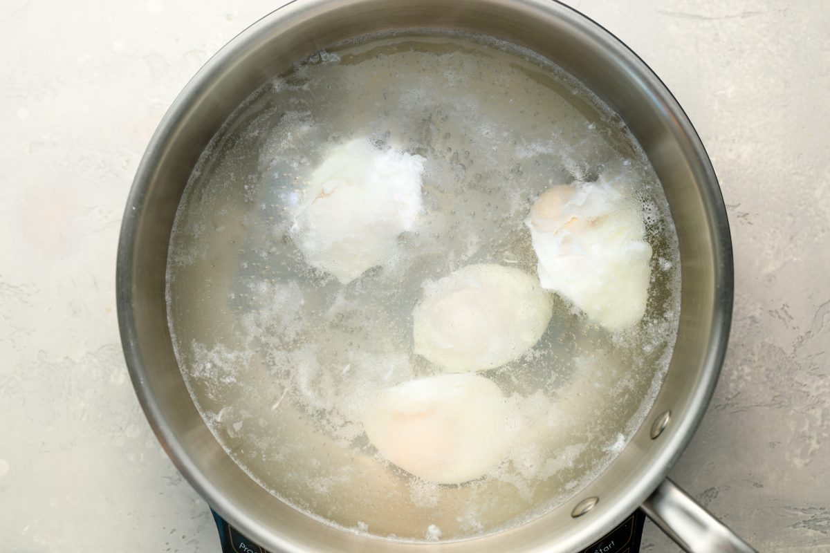 poaching eggs in simmering water
